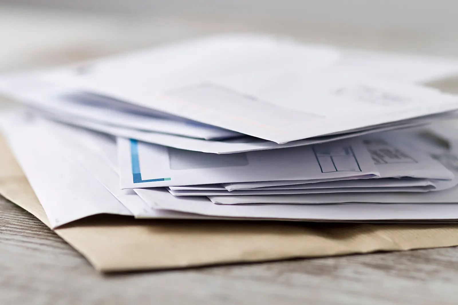 Stack of unopened business mail and envelopes representing high-volume enterprise mail processing