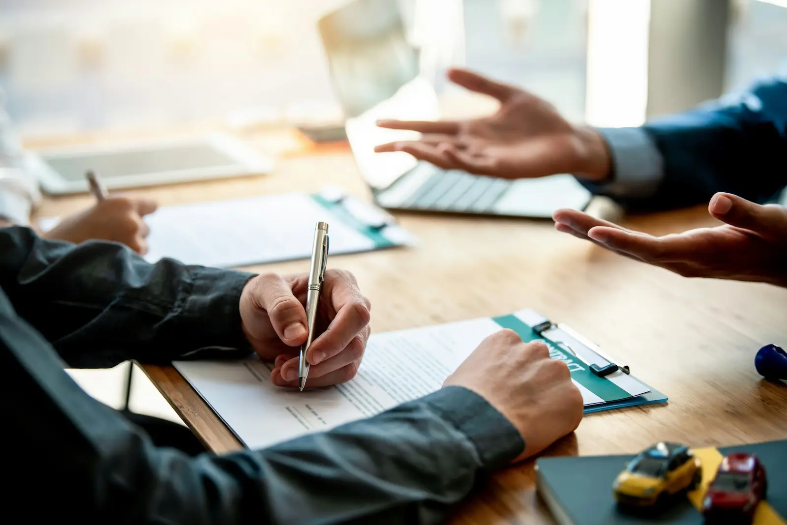 Insurance professional reviewing a claims intake form on a clipboard during a client meeting
