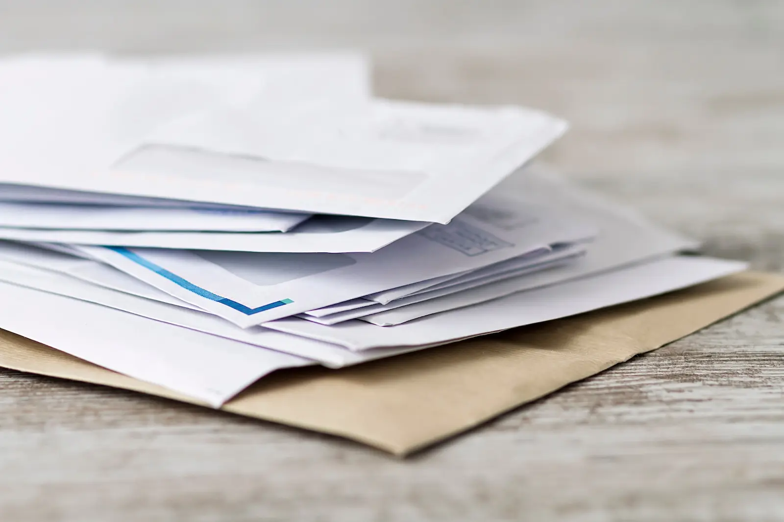 Stack of unopened business mail envelopes on a desk — missed legal notices can lead to default judgments and compliance penalties
