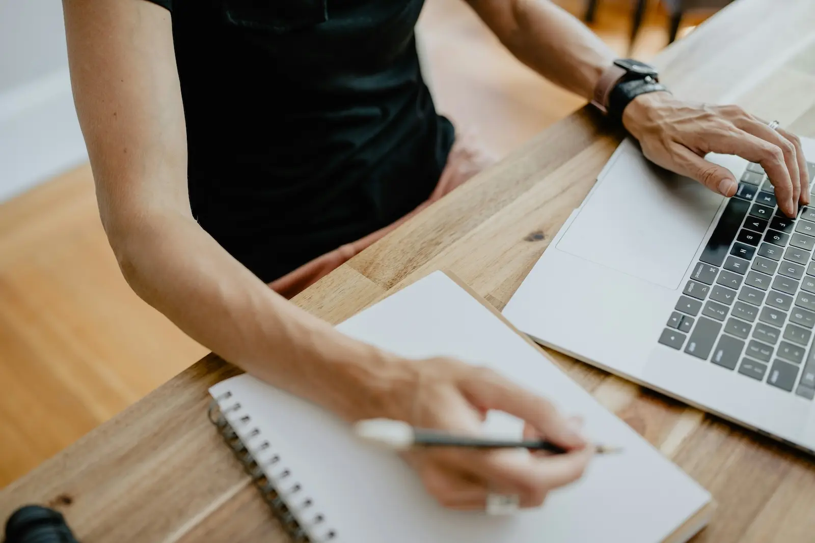 Business owner updating LLC internal records and operating agreement notes beside a laptop
