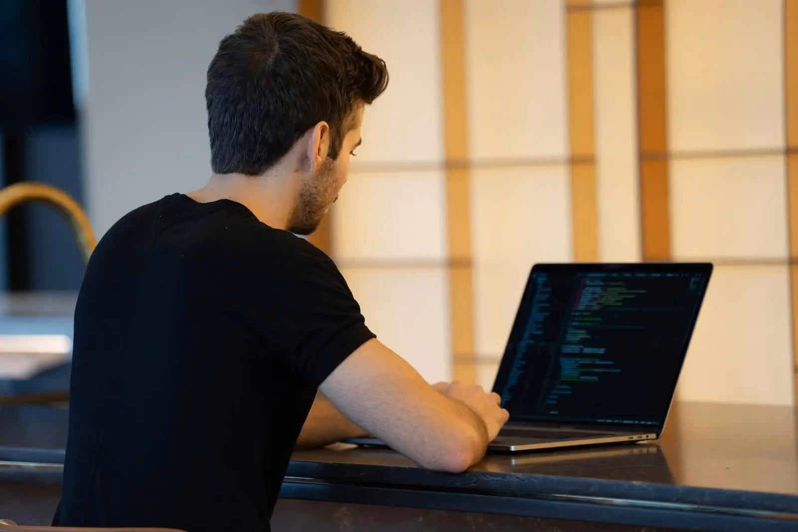 Developer writing code on a laptop to automate physical mail with the Stable API