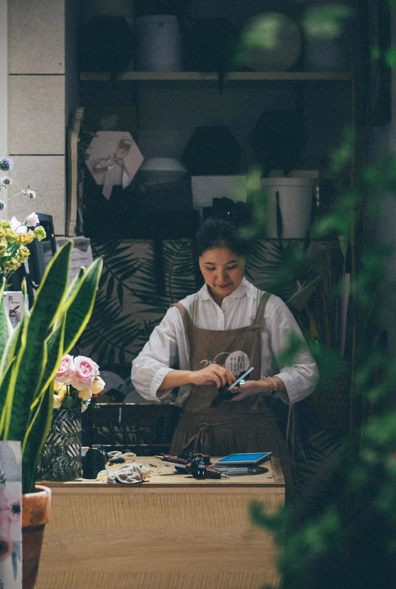 A woman arranging colorful flowers in a vibrant flower shop, showcasing her creativity and passion for floral design.