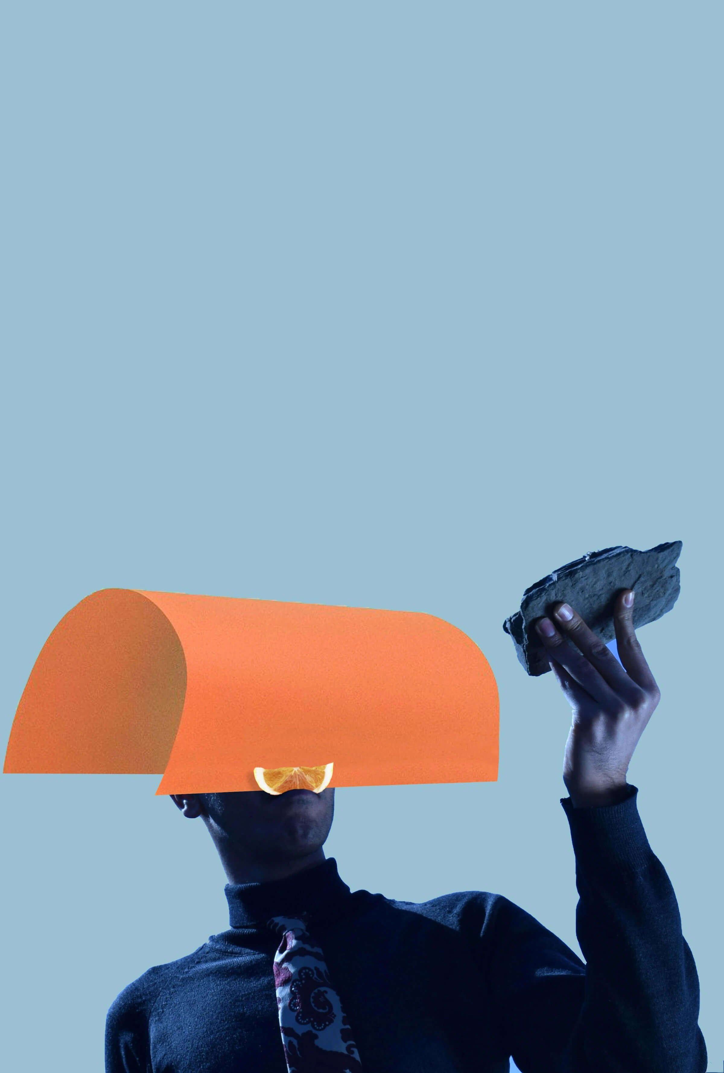 A man raises an orange above his head, showcasing the fruit in a joyful and triumphant manner.