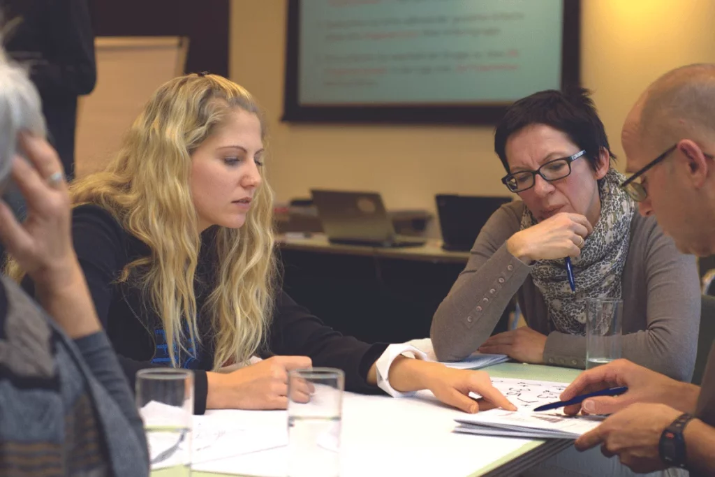 A team of professionals having a meeting, with documents spread out on the table.
