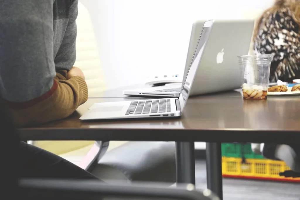 Casual workspace with an open MacBook and snacks on the table.