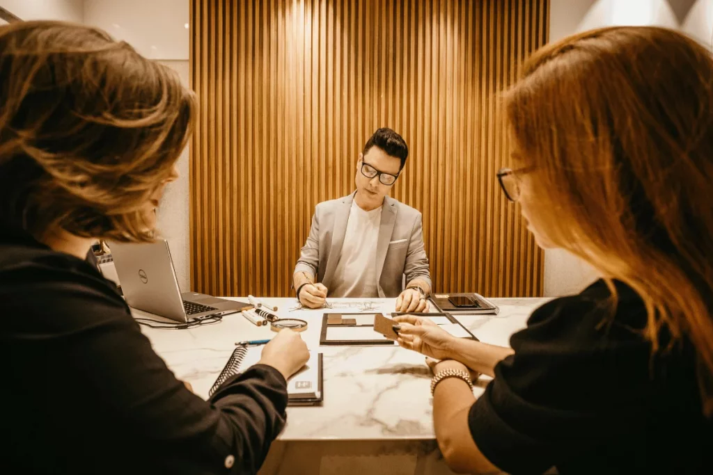 Team collaboration around a table with laptops and documents in an elegant setting.