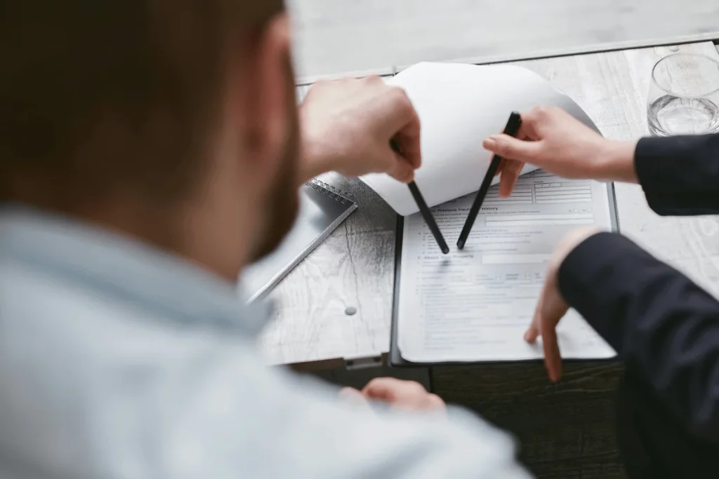Two professionals reviewing and pointing at a document during a discussion.