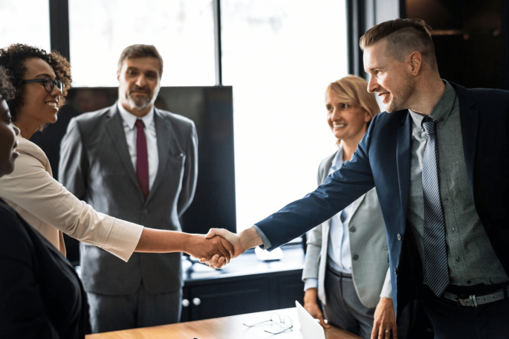 A group of business people shaking hands in an office.