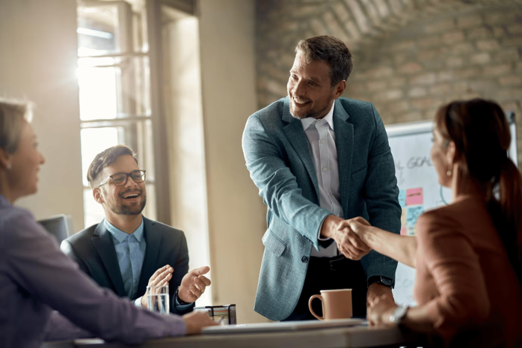 A group of business people shaking hands at a meeting.