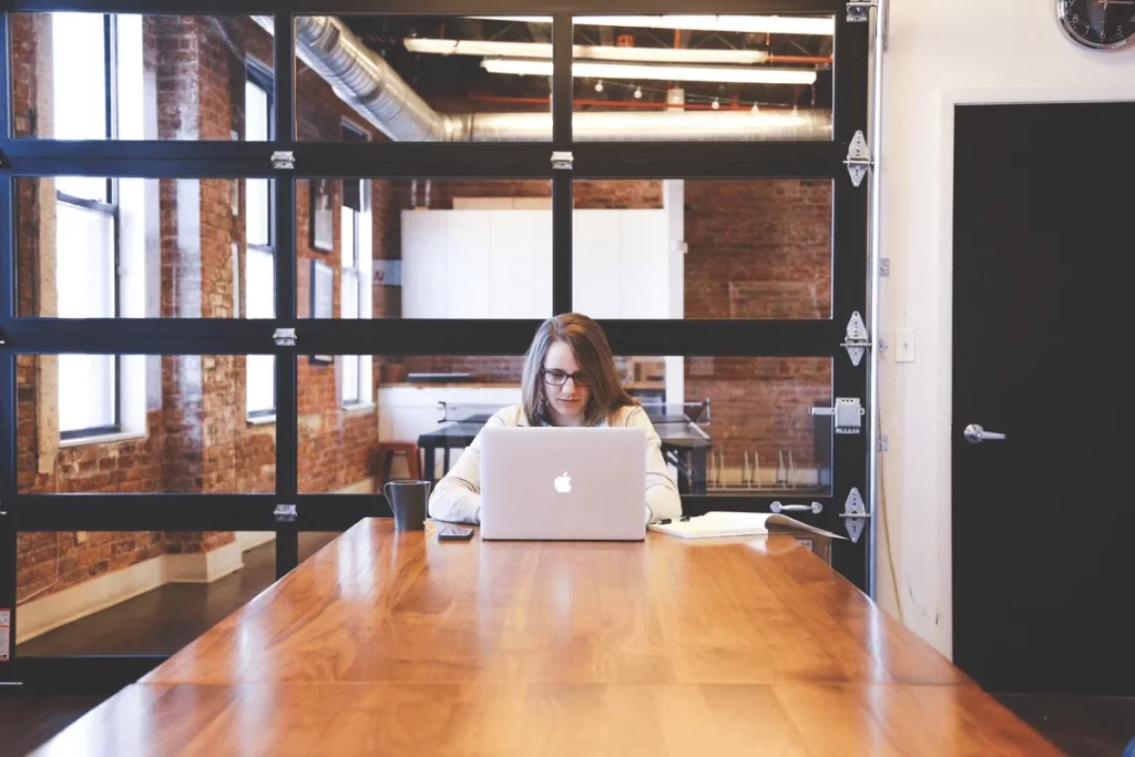 Concentrated female professional working on a laptop in a chic workspace.