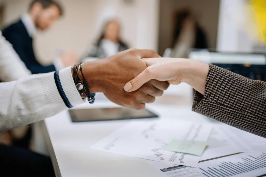 Close-up of a firm handshake between two professionals in an office.