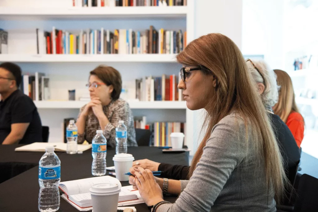 Professional business meeting in a modern office with bookshelves.