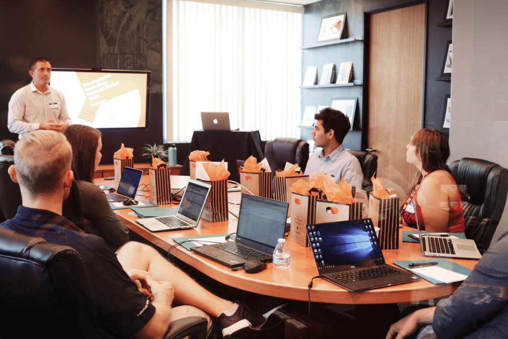 A presenter conducts a business meeting with attentive colleagues.