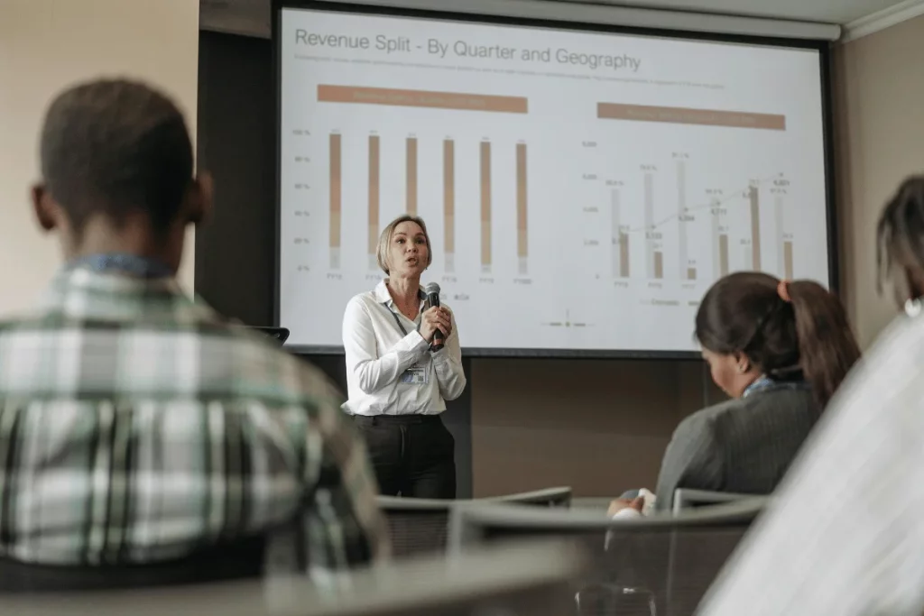 Executive presenting quarterly revenue split data to attentive audience.