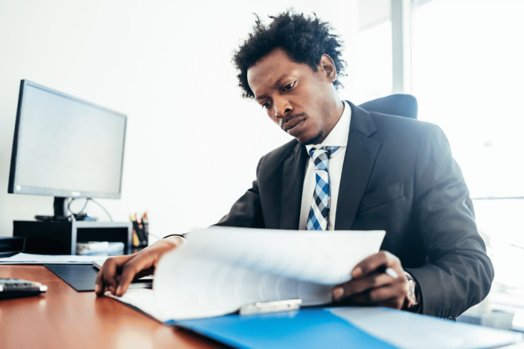 A person in a suit sitting at a desk with a piece of paper.