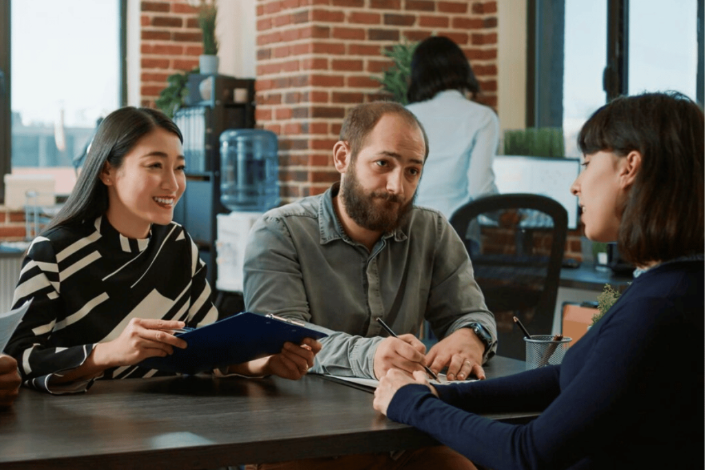 A group of people sitting at a table in an office.