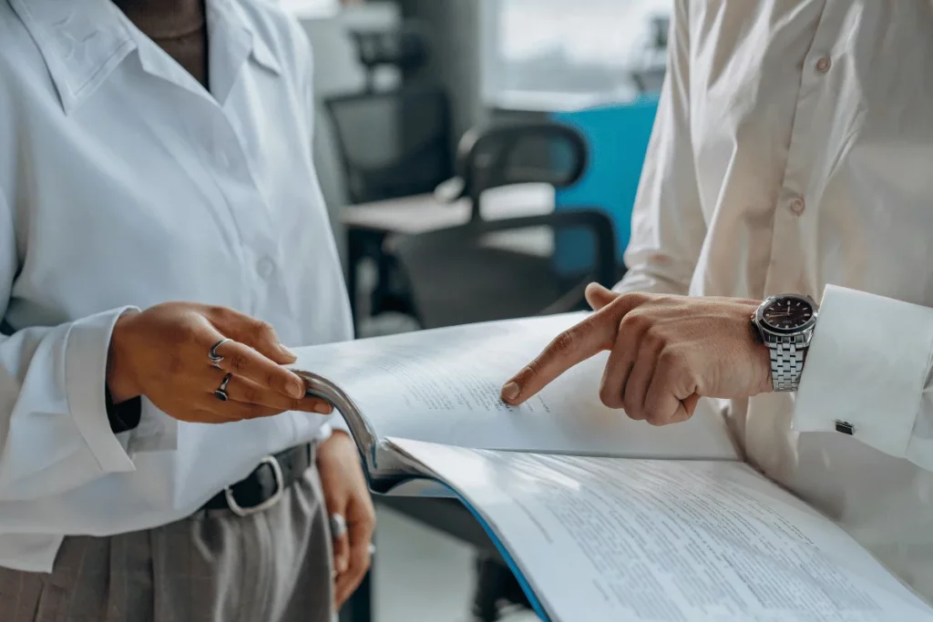 Close-up of colleagues in white shirts discussing a report with focused attention.