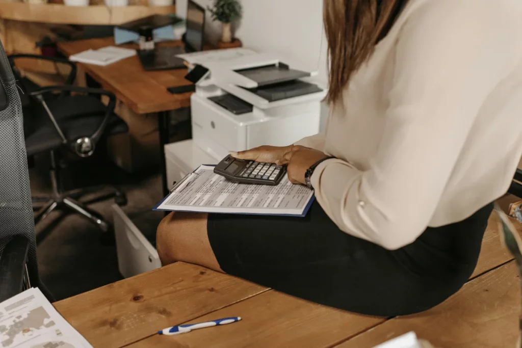 Close-up of small business accounting checklist and tax forms with reading glasses.