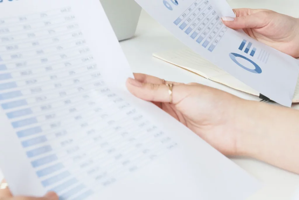A focused examination of printed spreadsheets containing numerical data and pie charts.