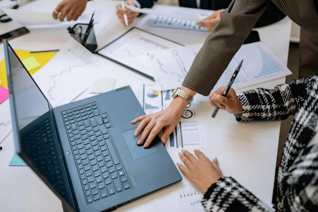 Busy workspace with people discussing market trends on charts.
