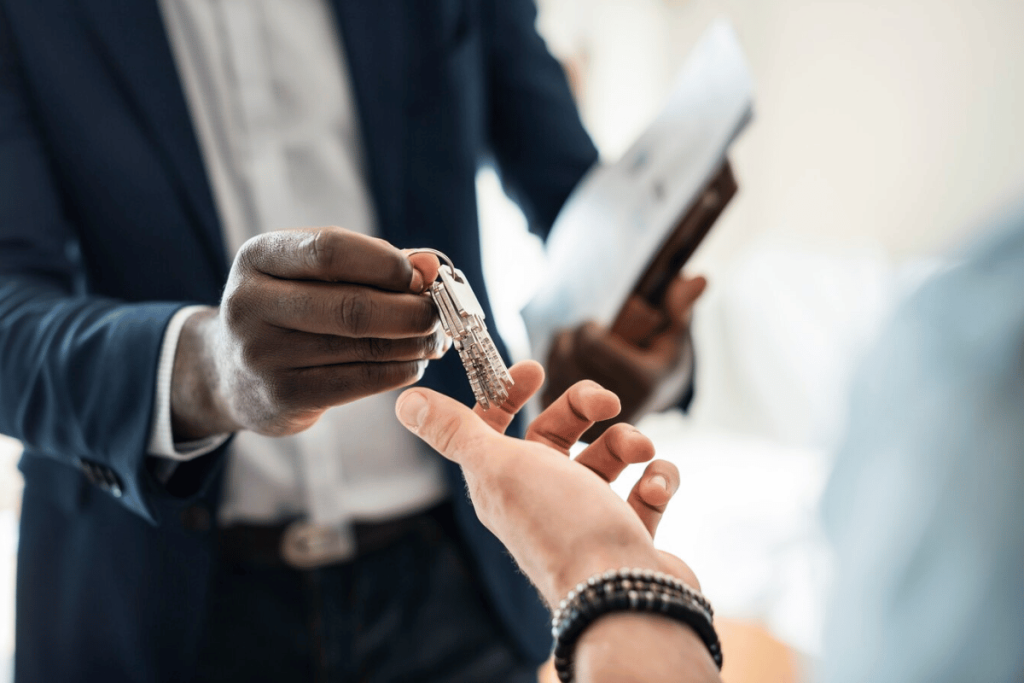 A person handing over a key to another person.