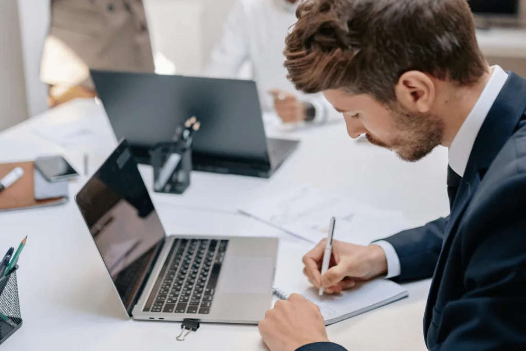 Young executive in a blue suit preparing reports at his workspace.