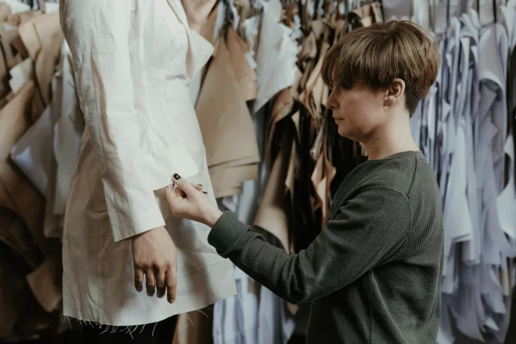 Tailor marking adjustments on a garment on a mannequin.