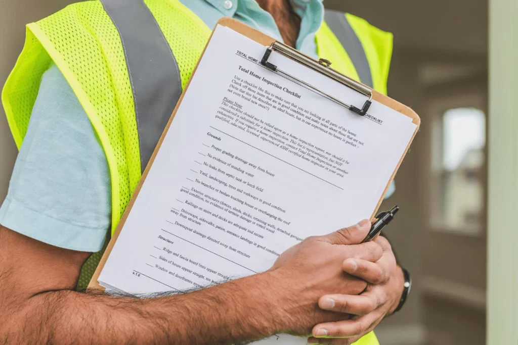 Inspector holding a clipboard with a home inspection checklist.