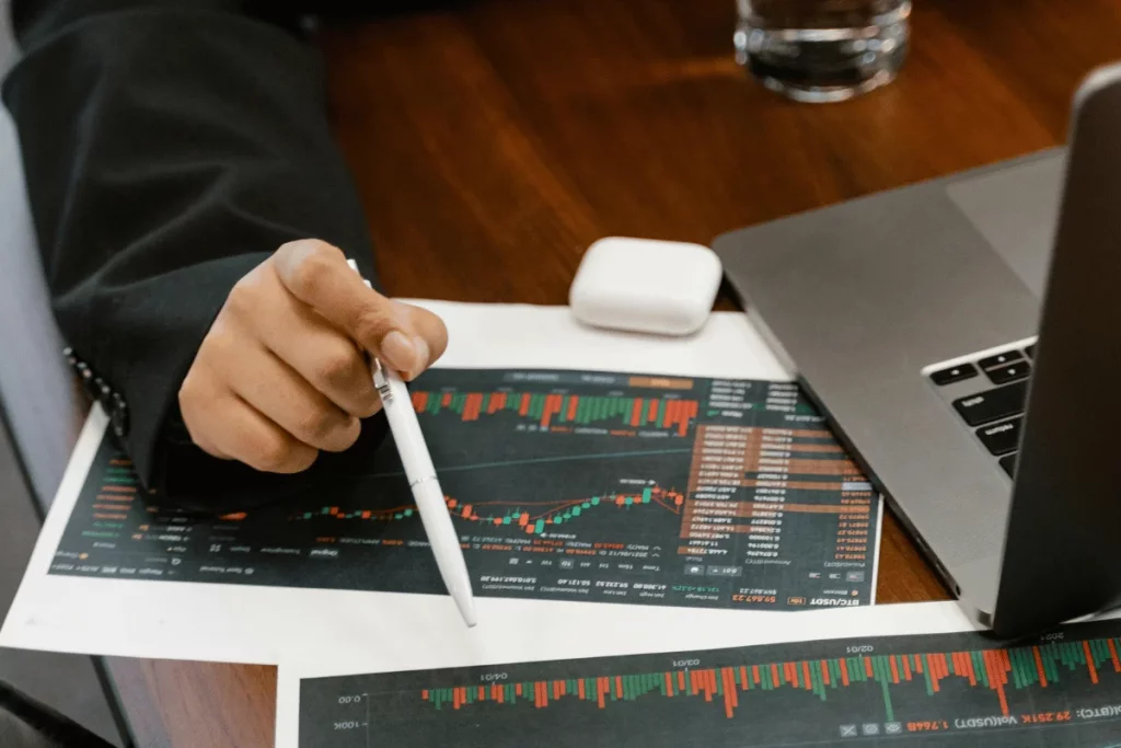 Business professional reviewing stock market charts on paper.
