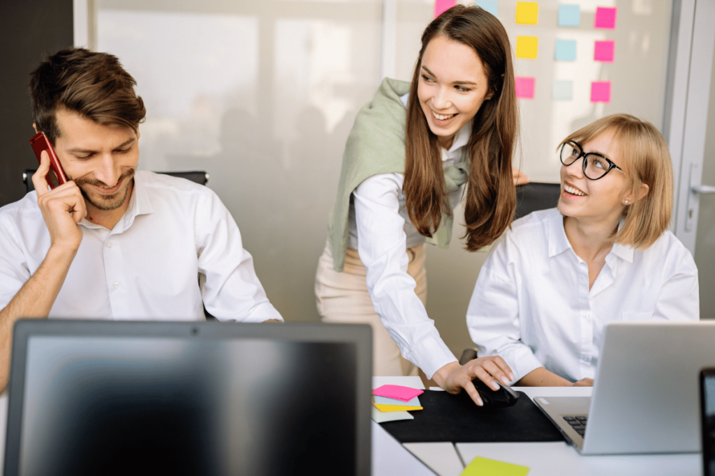 Team of three in office with one on phone and two women smiling.