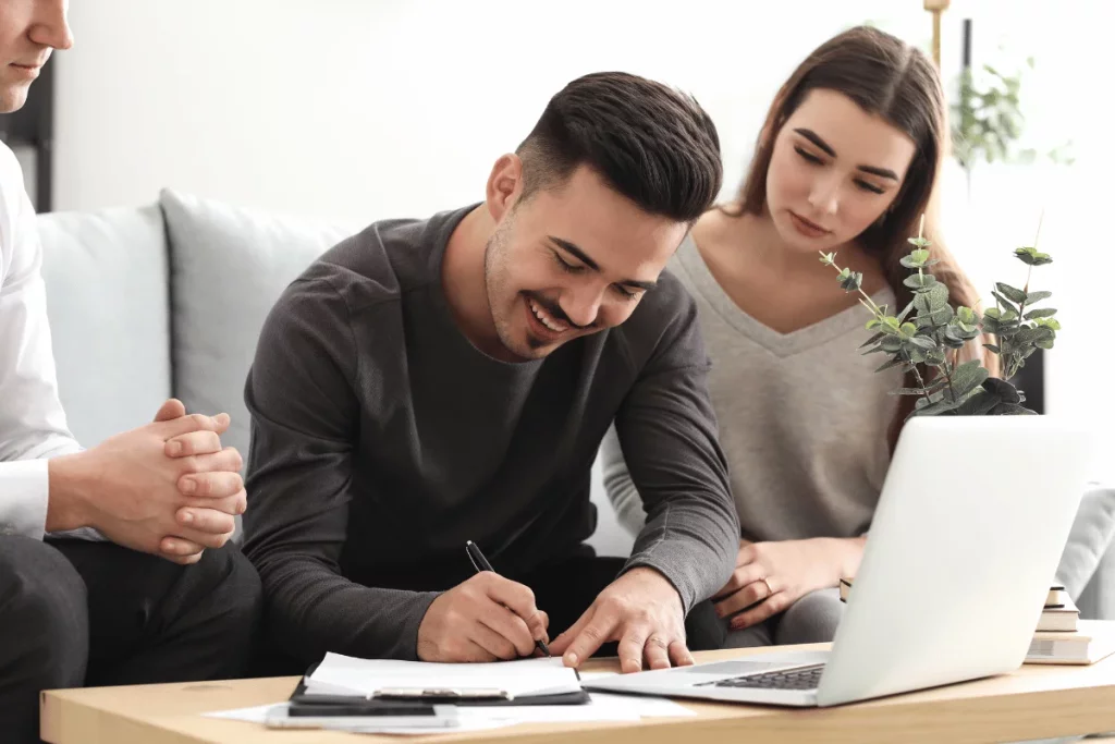 Couple signing a document with a financial advisor.