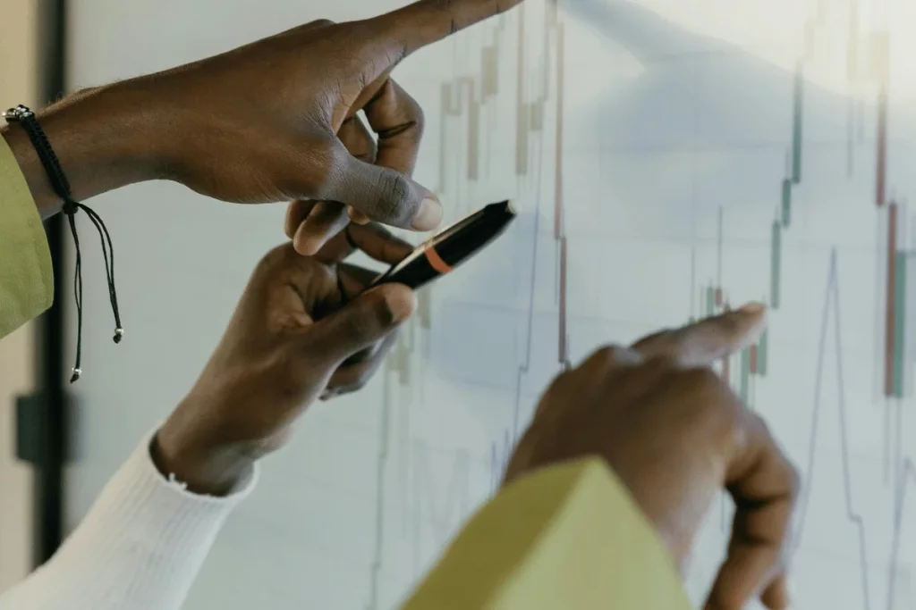 Close-up of hands analyzing financial trends on a digital screen.