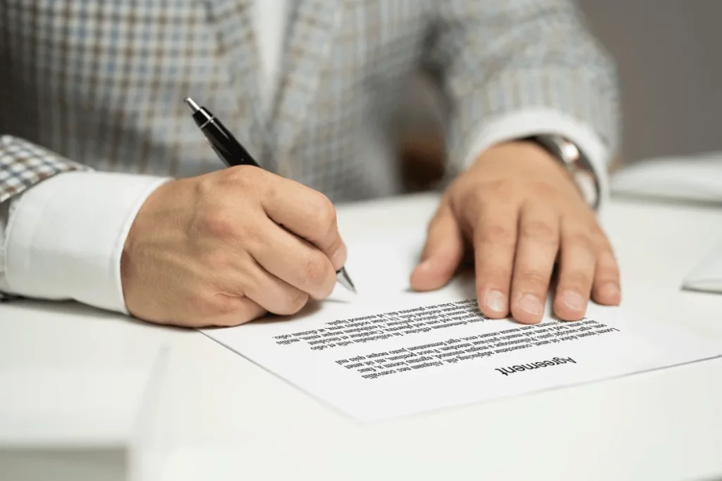Business professional signing an important agreement at the office.