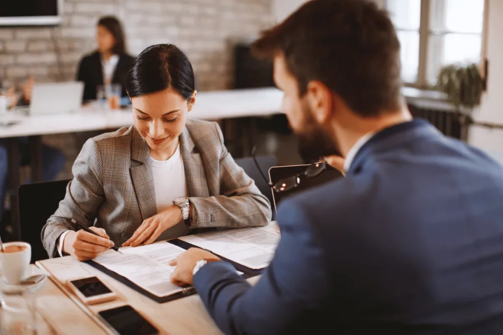 Businesswoman signing a contract in a meeting.