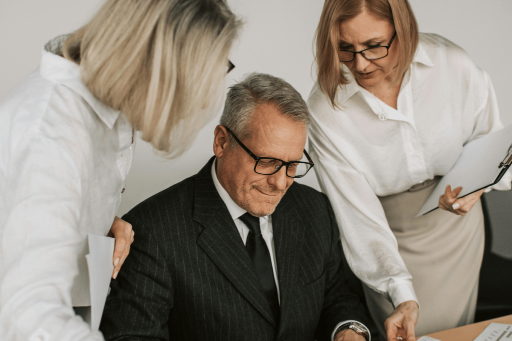 Senior businessman reviewing documents with colleagues.