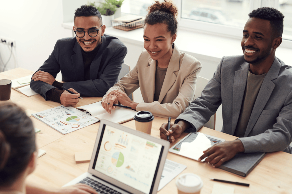 Enthusiastic team members discussing data at a well-lit office table.