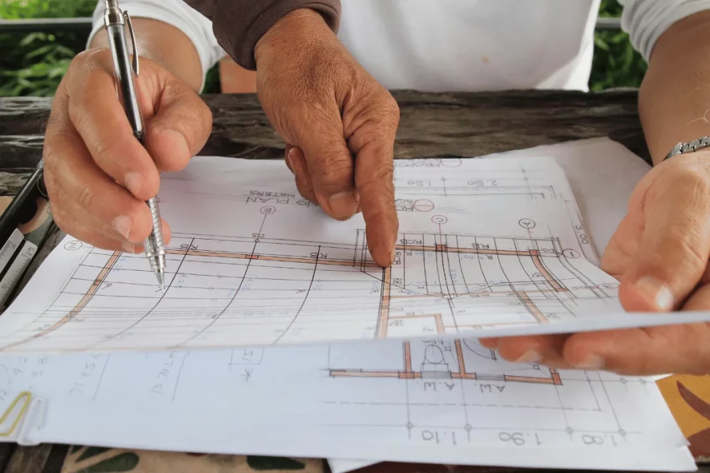 Close-up of an architect working on blueprints outdoors.