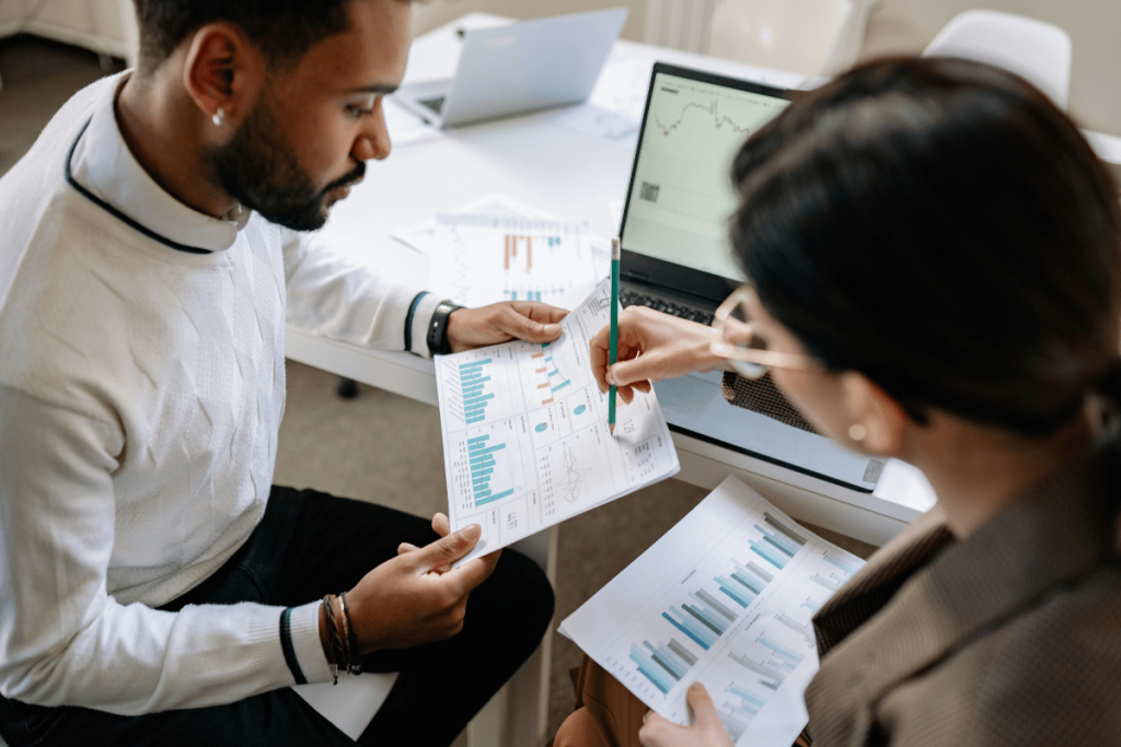 Two professionals analyzing financial charts in a focused business meeting.