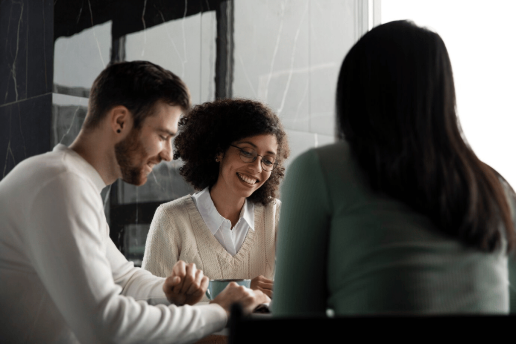 Three people sitting at a table having a conversation.
