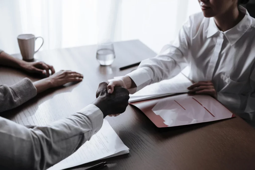 Corporate agreement sealed with a handshake at a wooden office table.