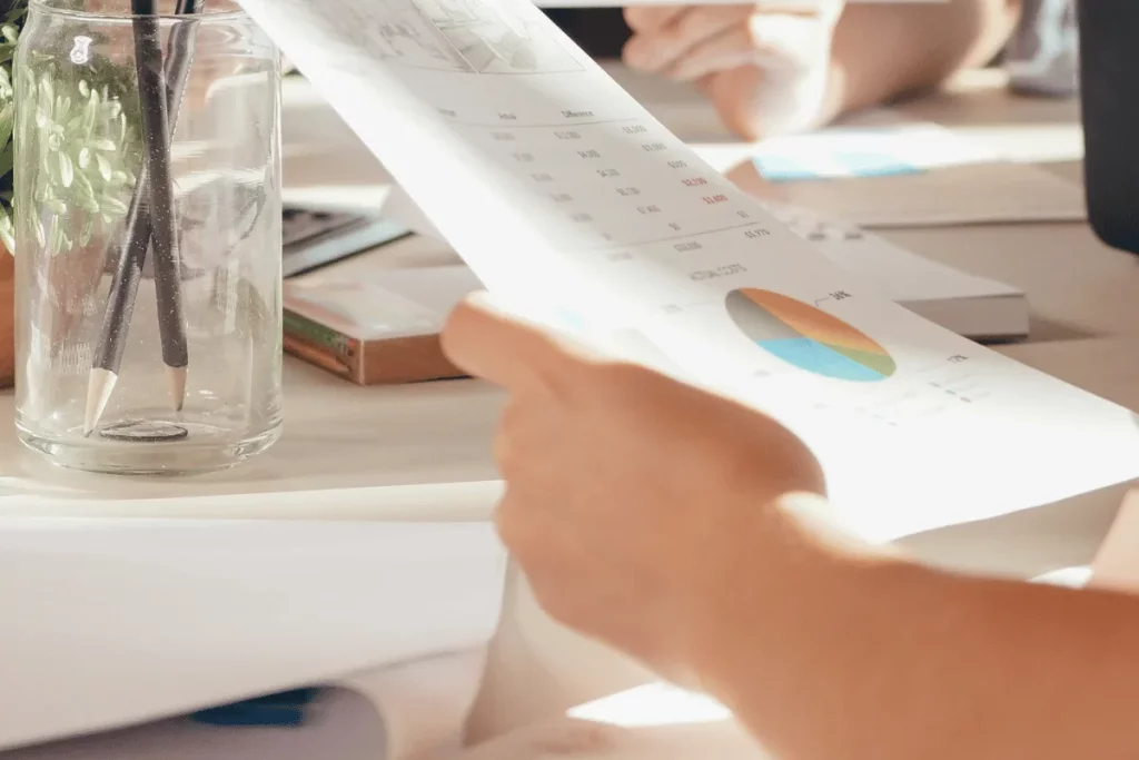 Finger pointing to a pie chart during a financial review meeting.