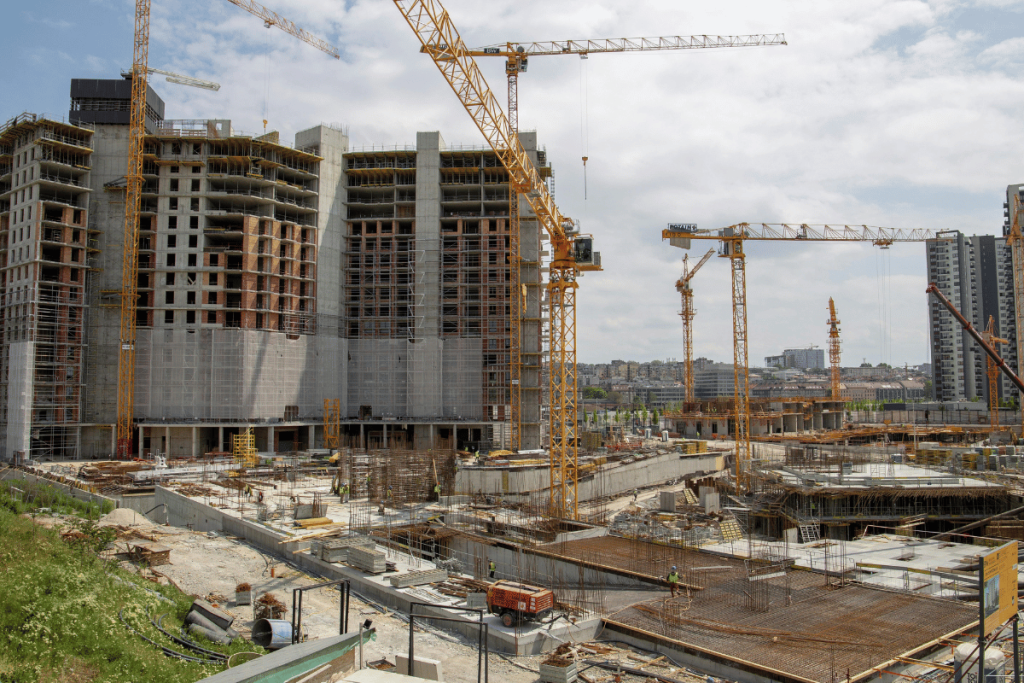 Busy construction site with multiple cranes and developing high-rise buildings.