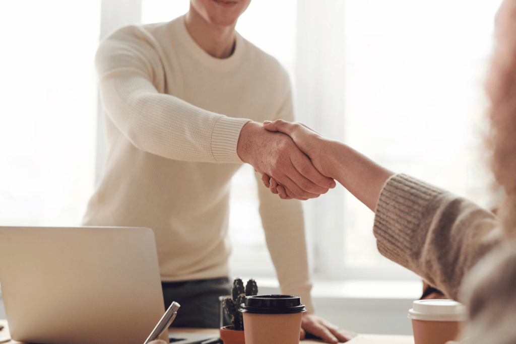 Professional handshake over a work desk.