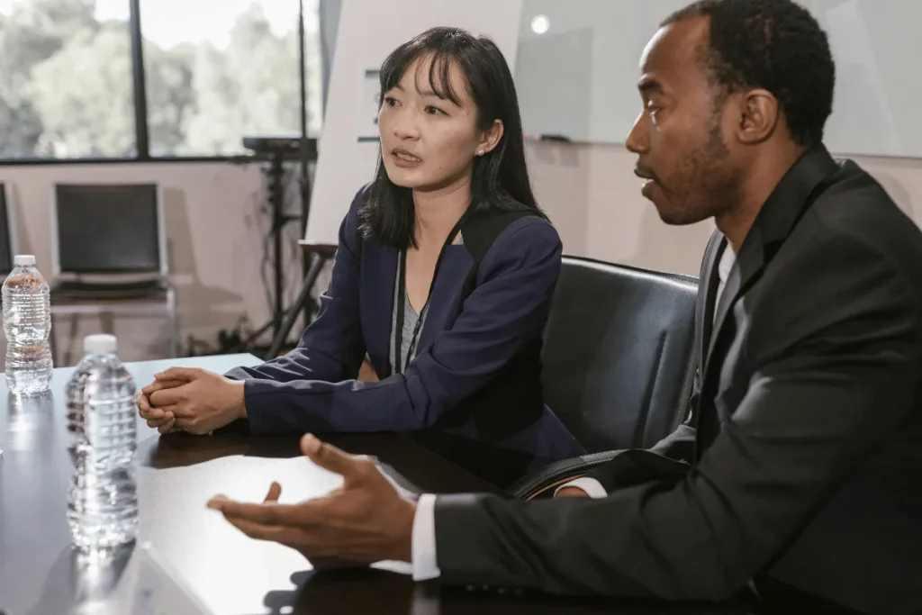 Two business professionals in a serious discussion at a conference table.