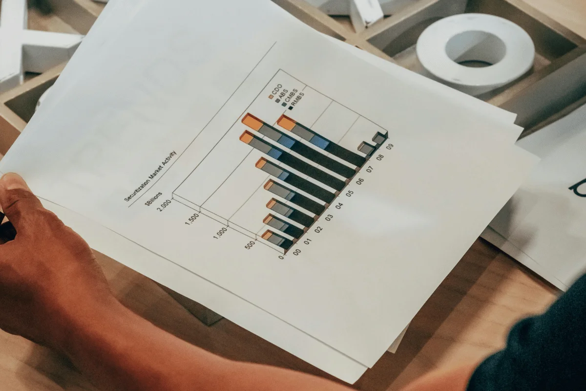 Person holding a printed graph showing market activity.