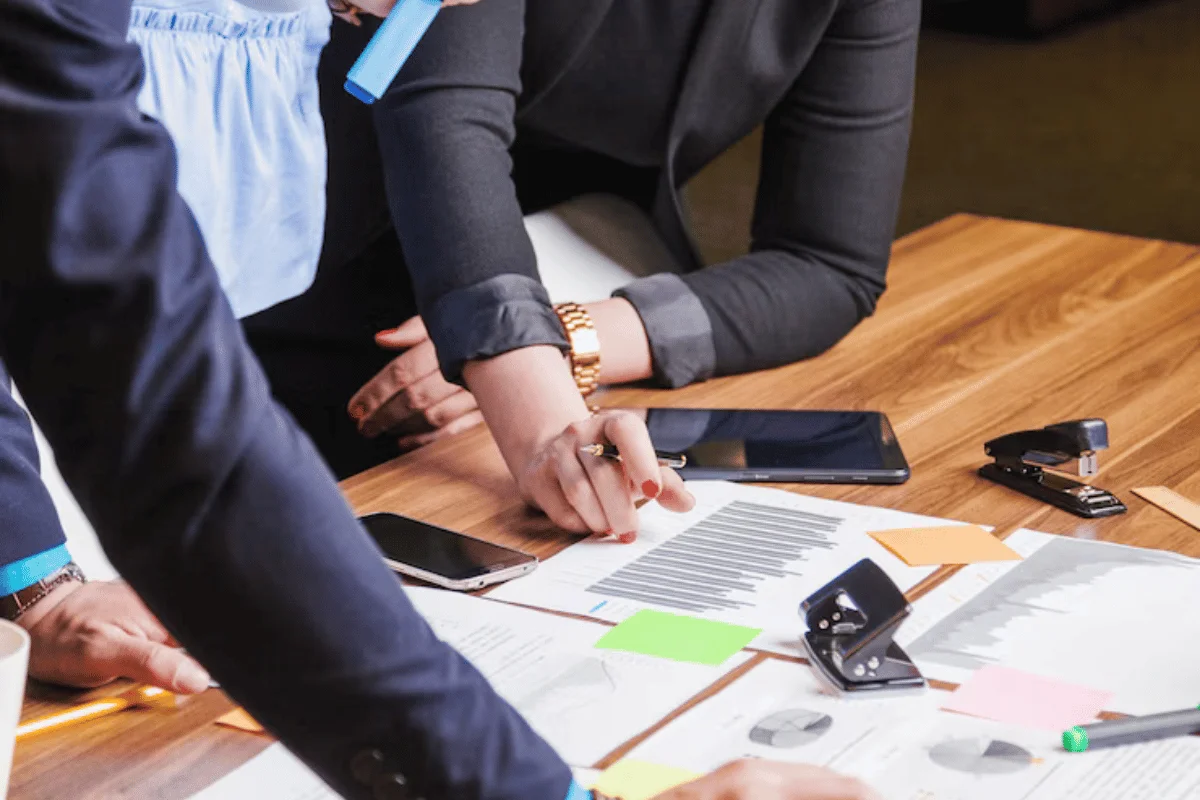 Business professionals analyzing charts and graphs in a meeting.