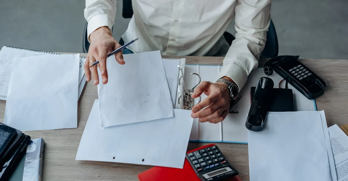 Business professional organizing documents and financial papers on desk while preparing for SaaS M&A firms evaluation.