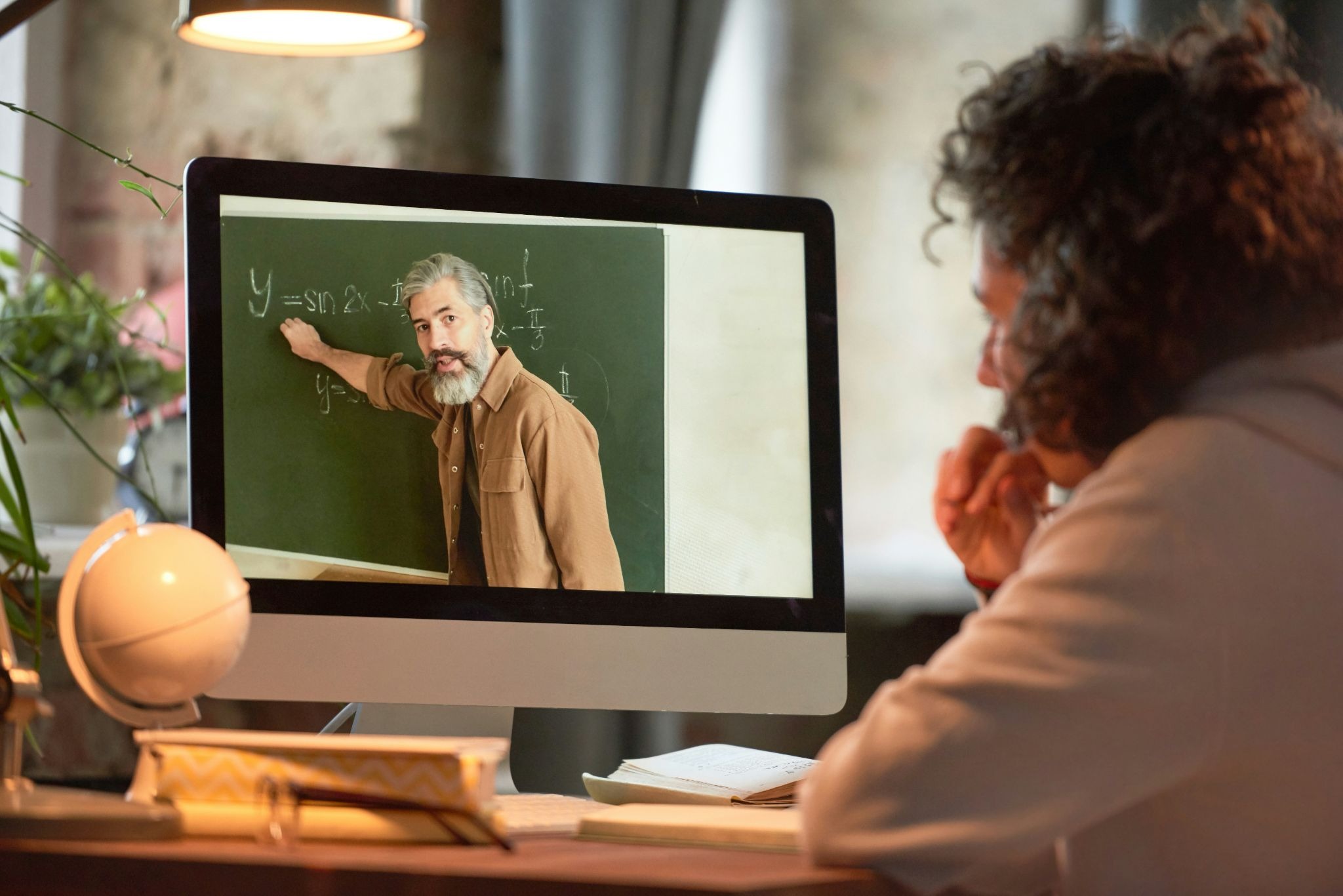 Online math tutor teaching students in a virtual classroom using a shared digital whiteboard, online equation editor, and live video during an online math tutoring session.