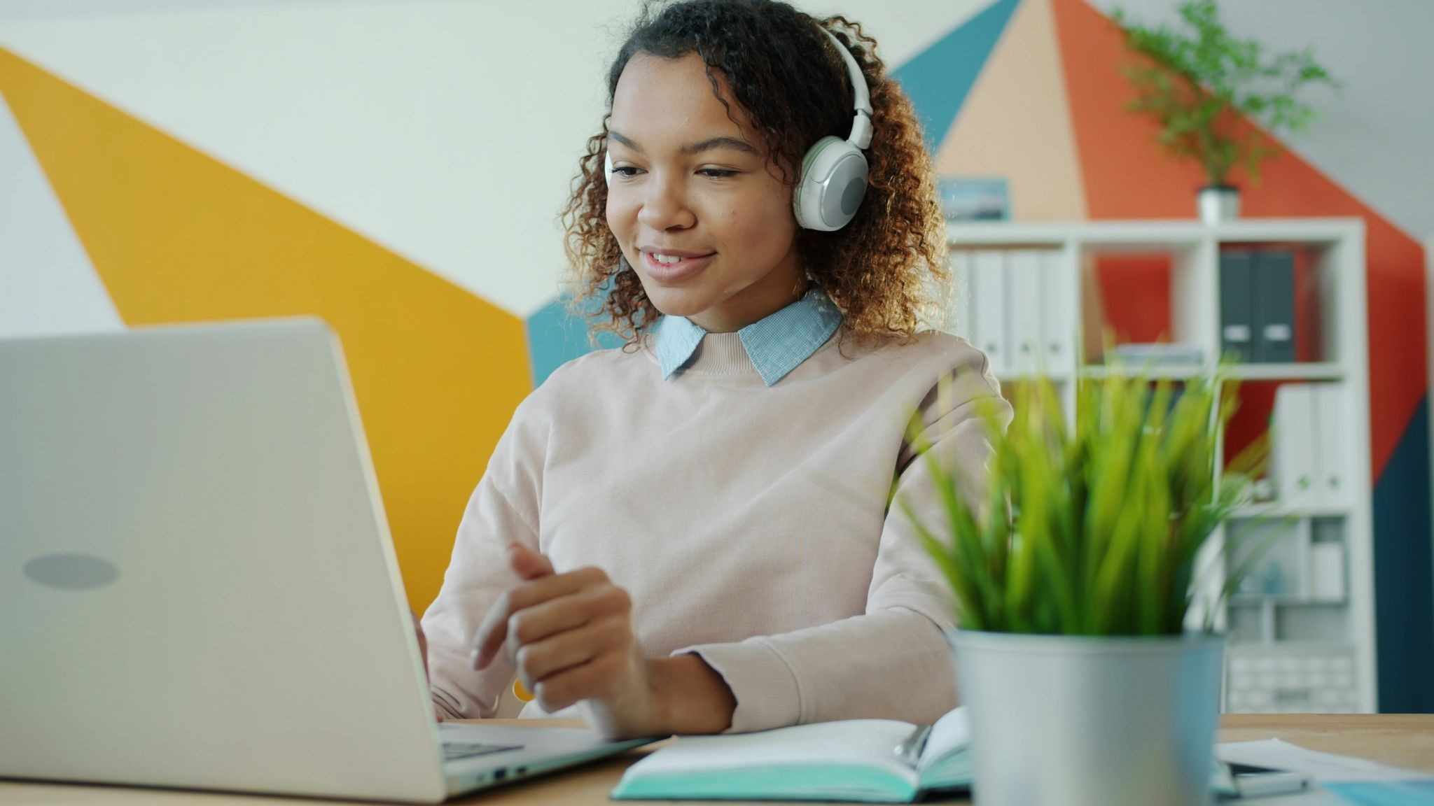 Student wearing headphones and participating in a virtual breakout room during an interactive online class.
