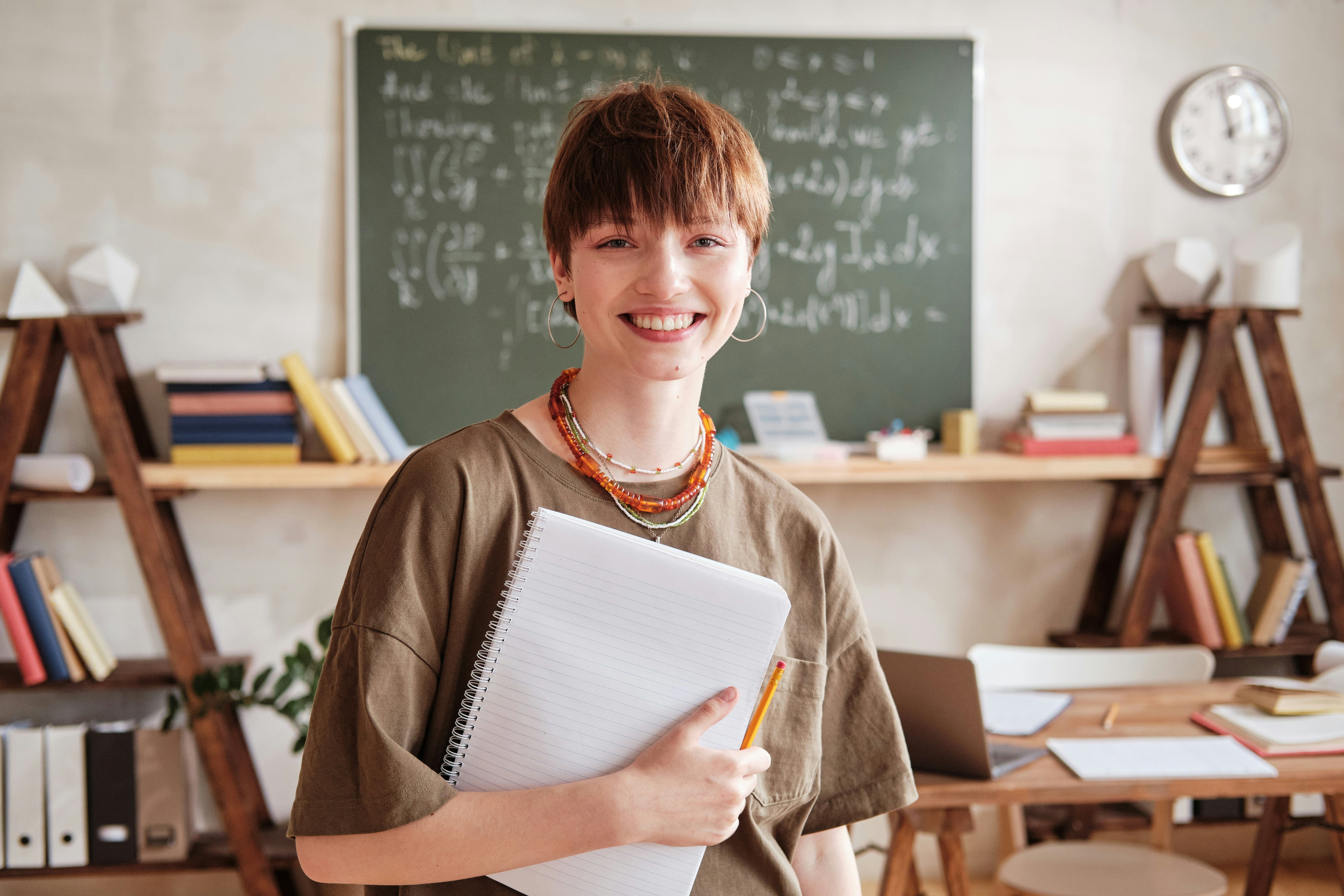 Tutor with books, a laptop, and a notebook choosing a virtual classroom platform to grow a tutoring business.